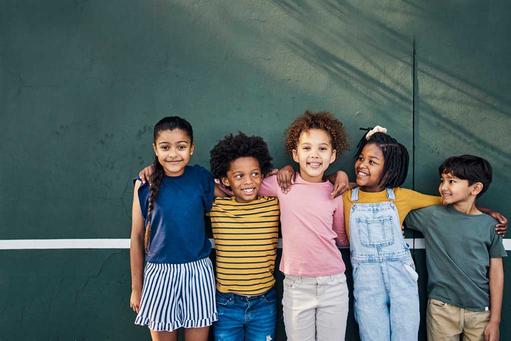 
		Group of young children relaxing on a tennis court		