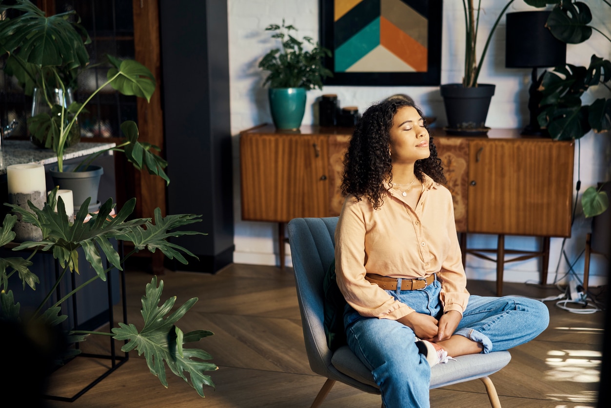 Woman sitting on chair taking time to think about an holistic approach to her wellness