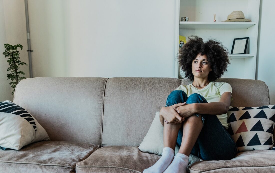 A sad young women sitting by herself, not seeking help due to mental health stigma