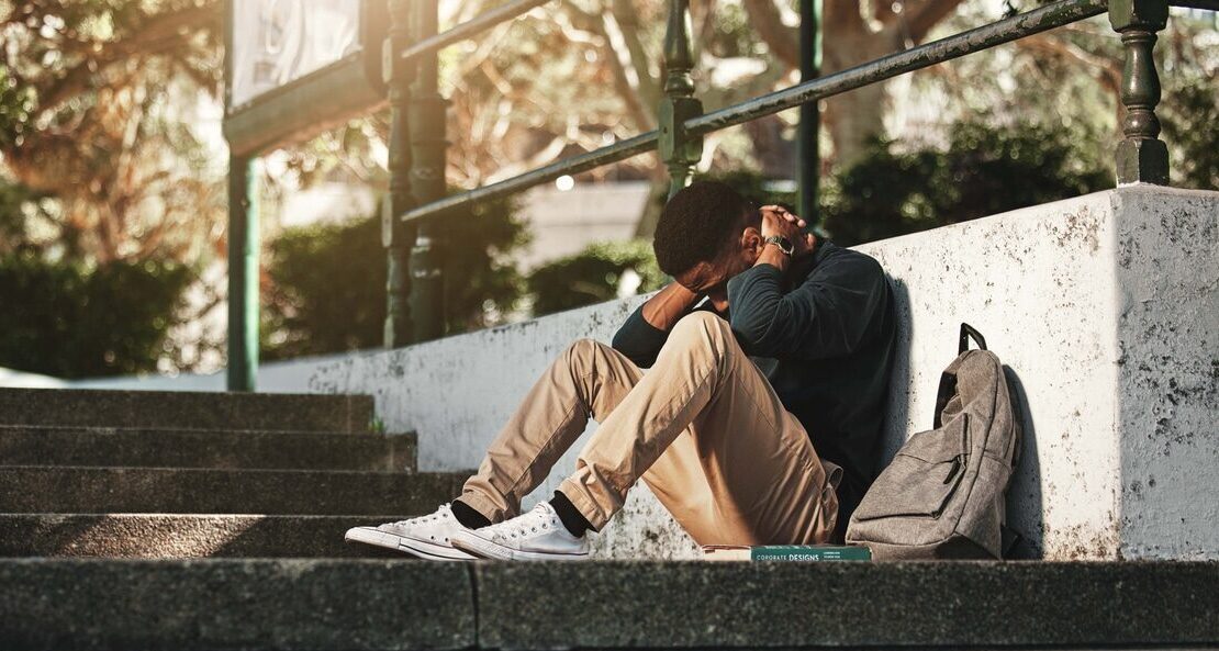 Young man suffering from depression sitting on steps