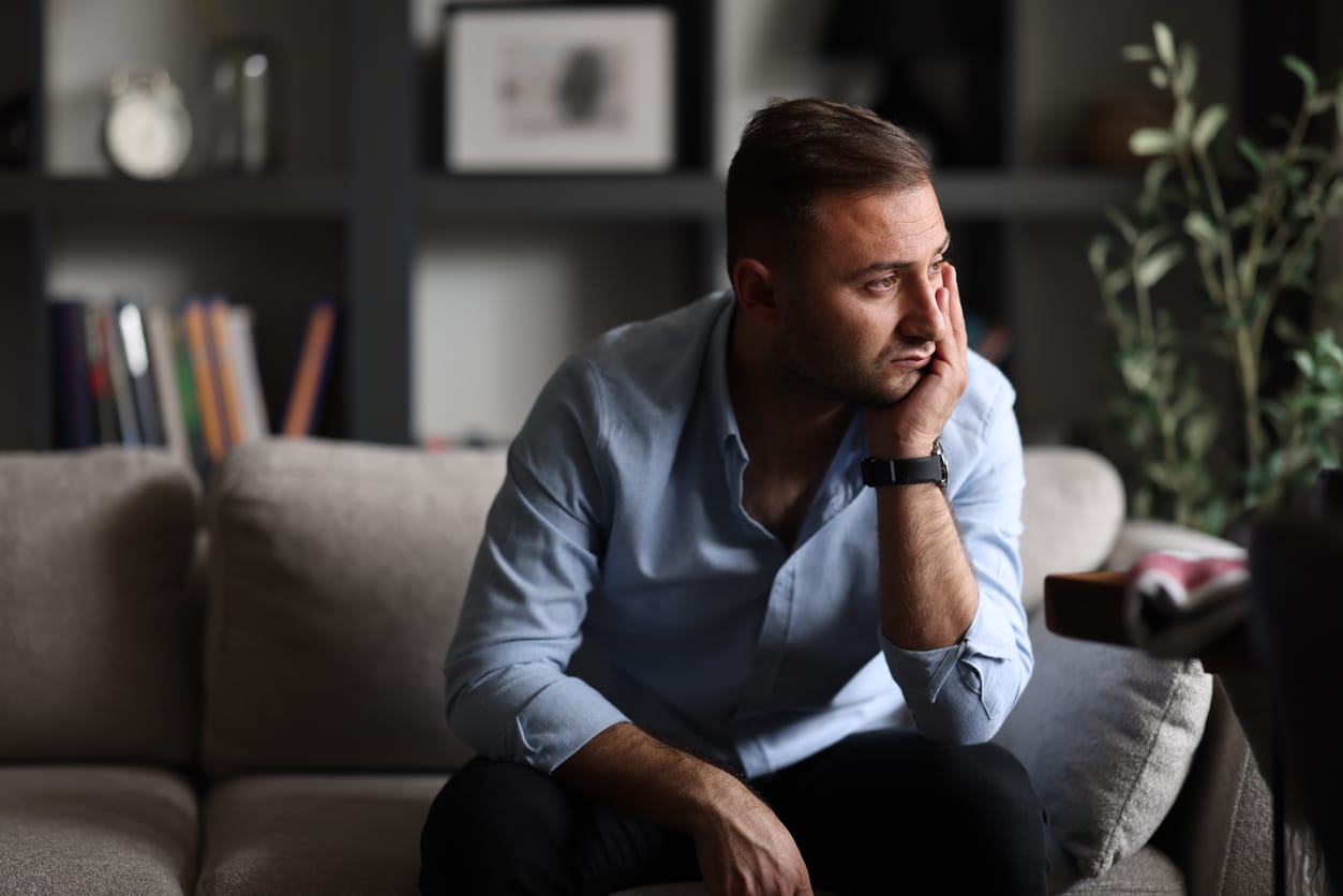 Man sitting and thinking while trying to cope with the grief and loss of his sibling