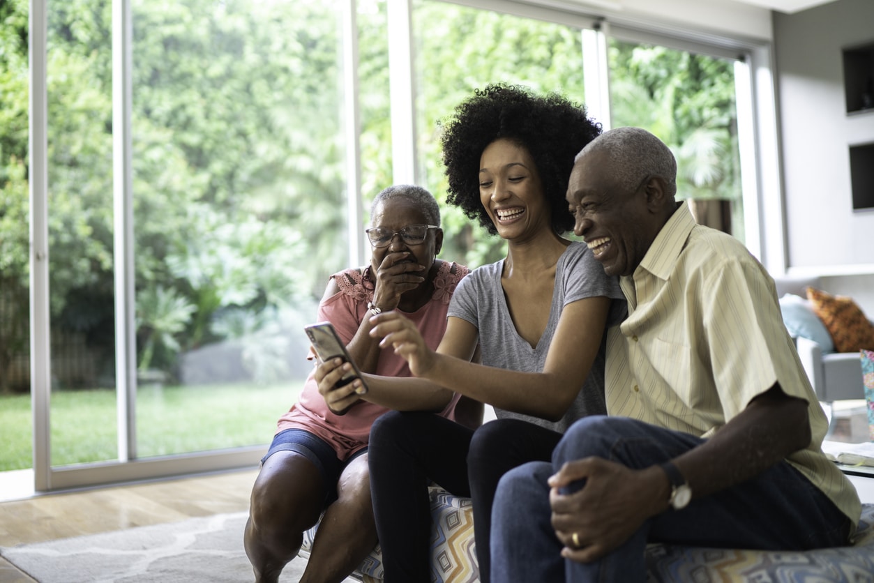 Granddaughter helping her grandparents virtually connect with long-distance family in a different country after emigration.