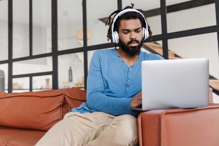 Man on laptop working and listening to audio