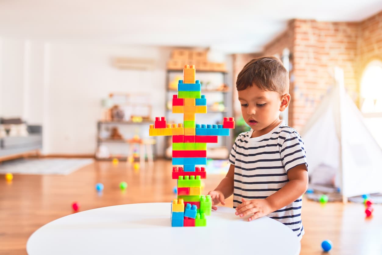 child playing with colourful building blocks