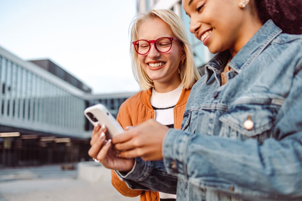 Carefree young women using smart phone