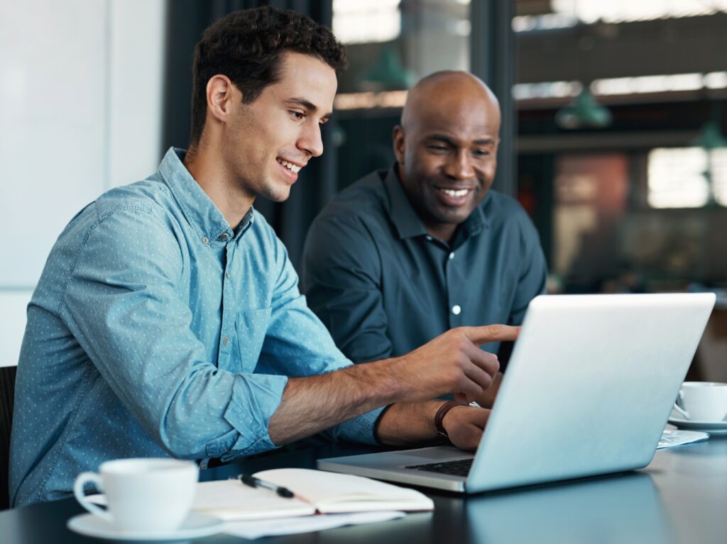 Two men discussing work things with laptop in front of them