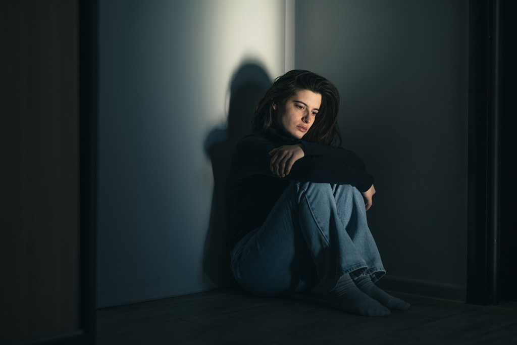 Self-harm image of girl in dark room